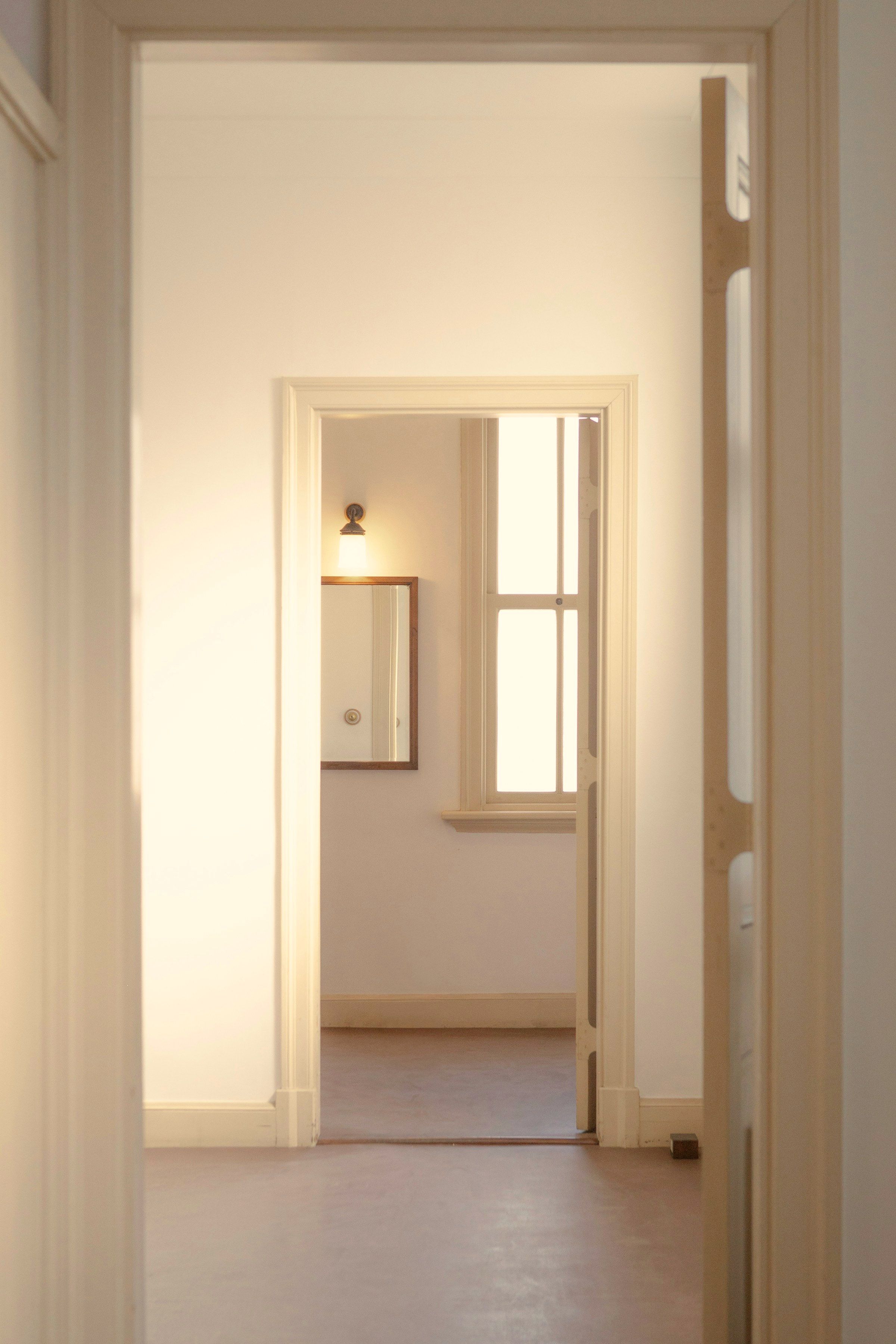 The enfilade: one doorway framing the next, and the next framing a lit window at the end of the run of rooms.