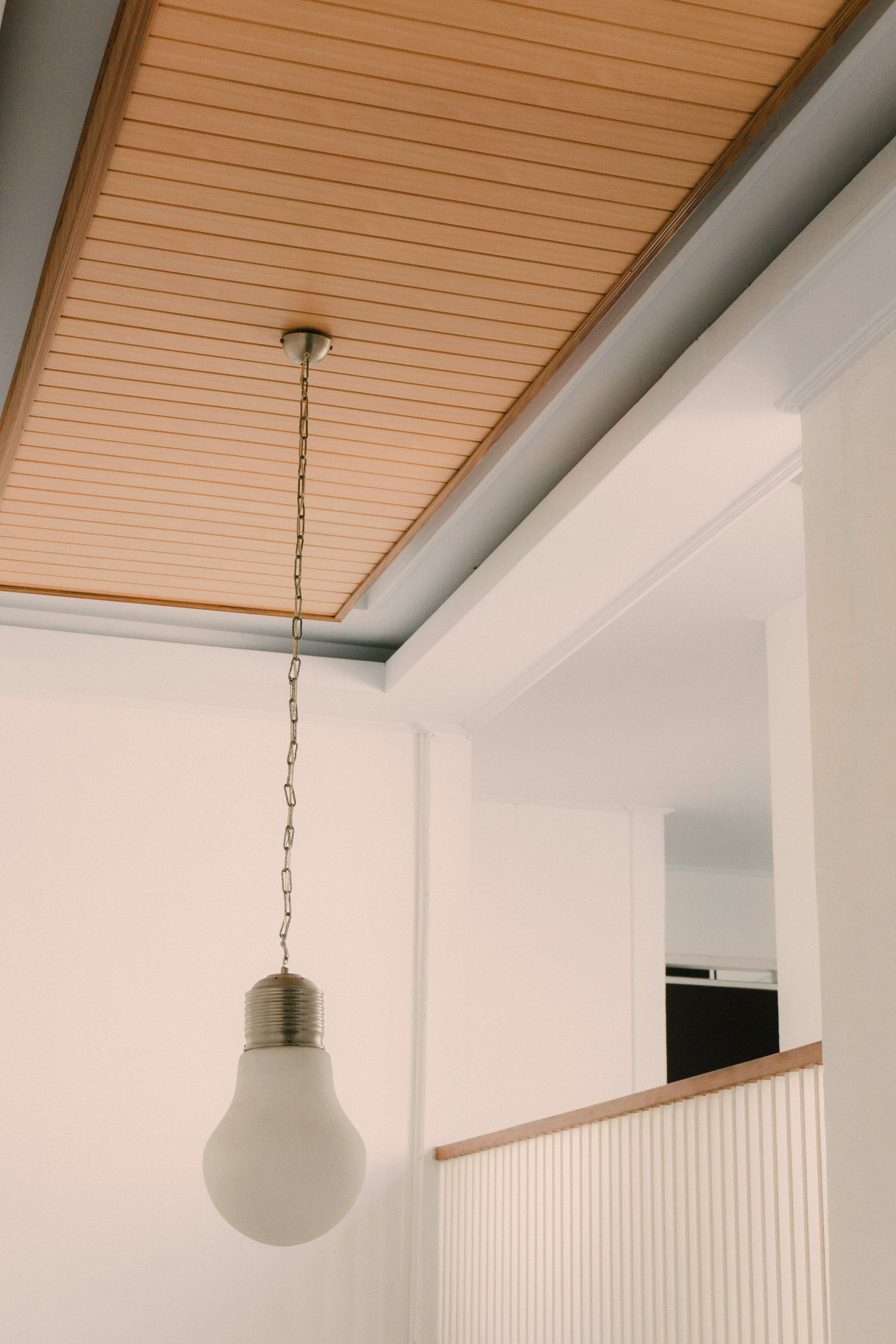 The oak ceiling: a close-boarded timber panel set into a white plastered soffit, seen from below with a pendant on a chain.
