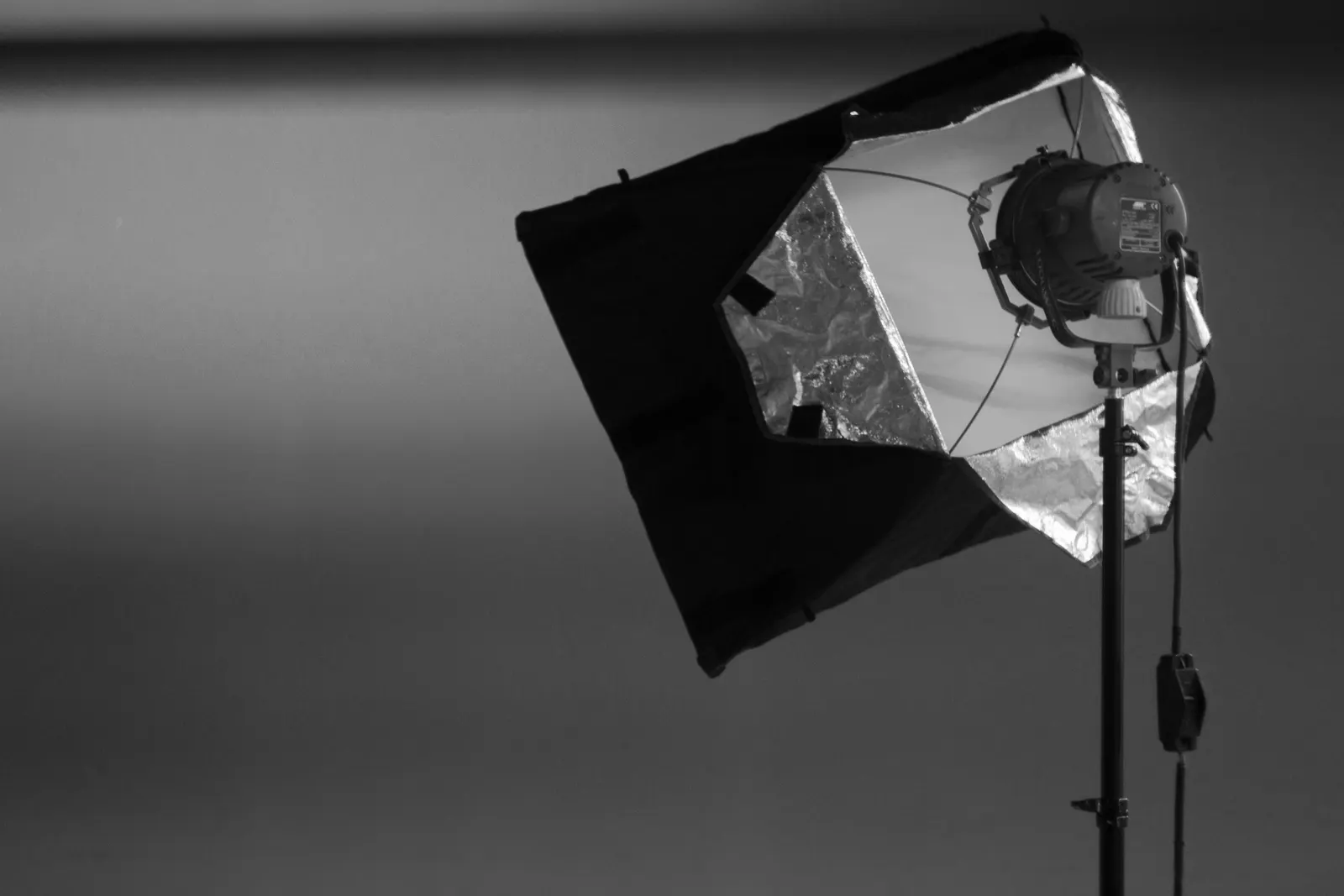 A small softbox and a head on a stand in a dark studio