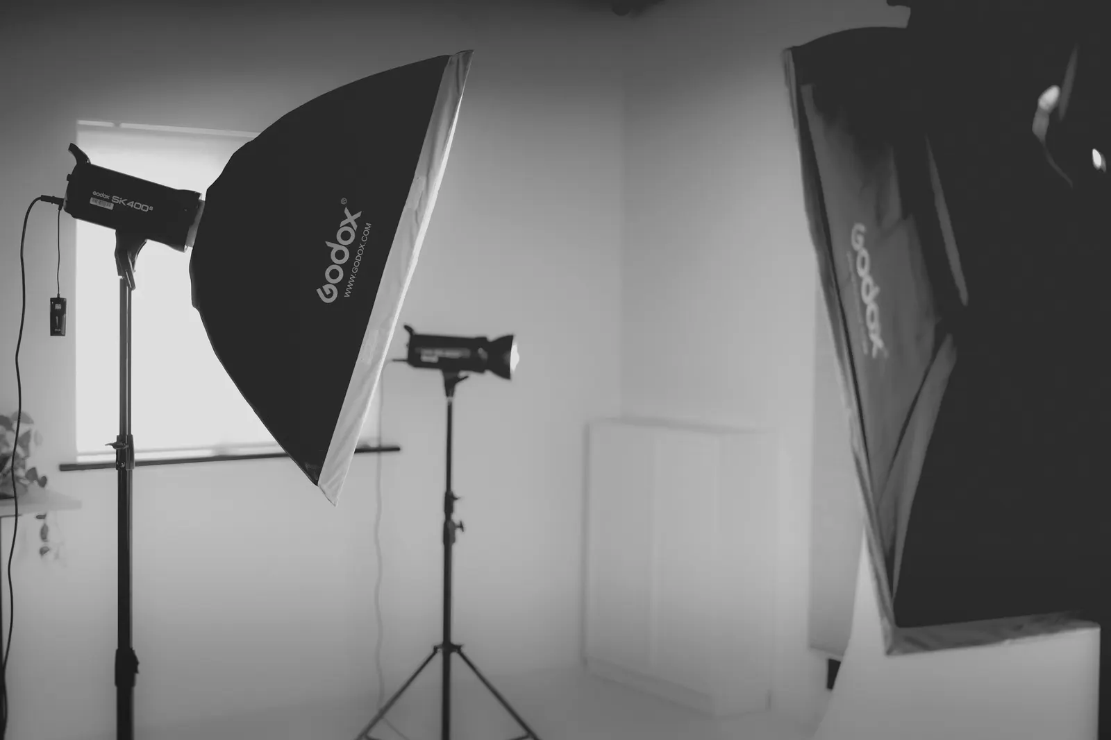 Two softboxes on stands in a small white studio