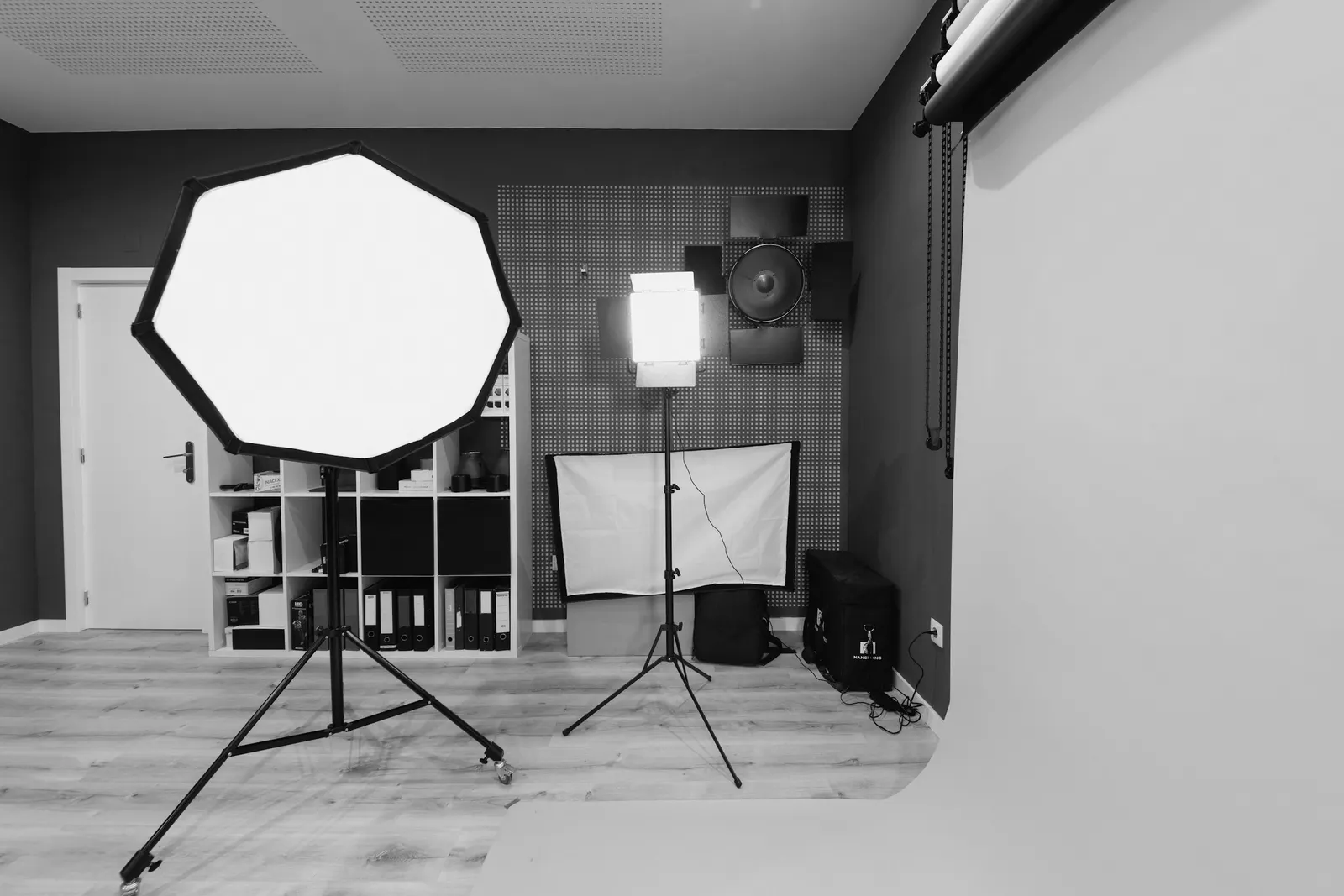 A small studio with an octagonal softbox and shelves of gear