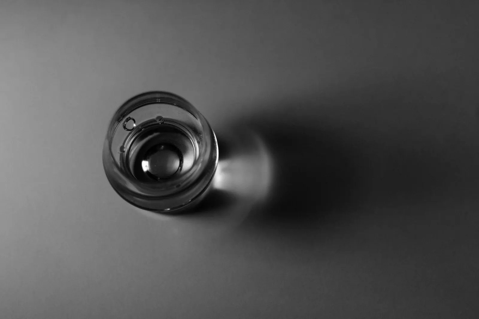 A small glass seen from above on a dark ground