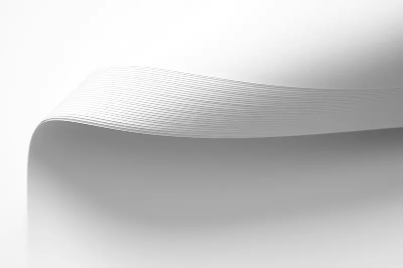 A curved sheet of white material on a white background