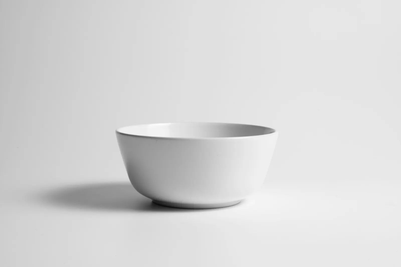 A plain white bowl on a white table