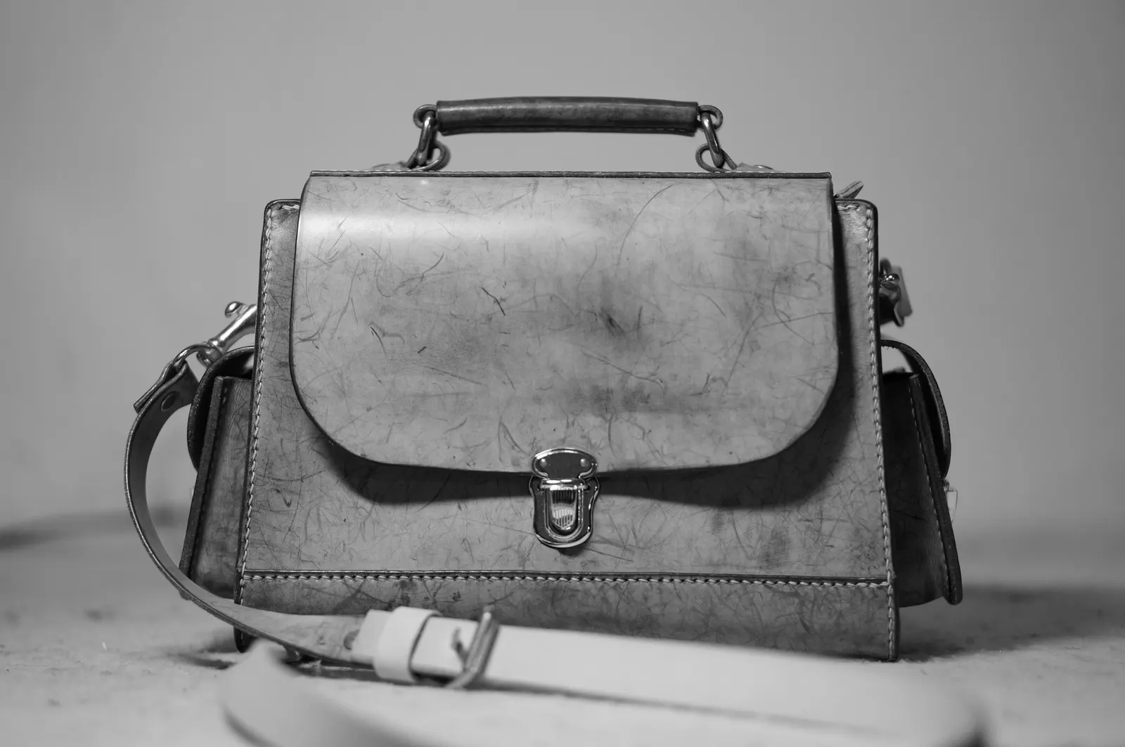 A worn leather satchel with a brass clasp