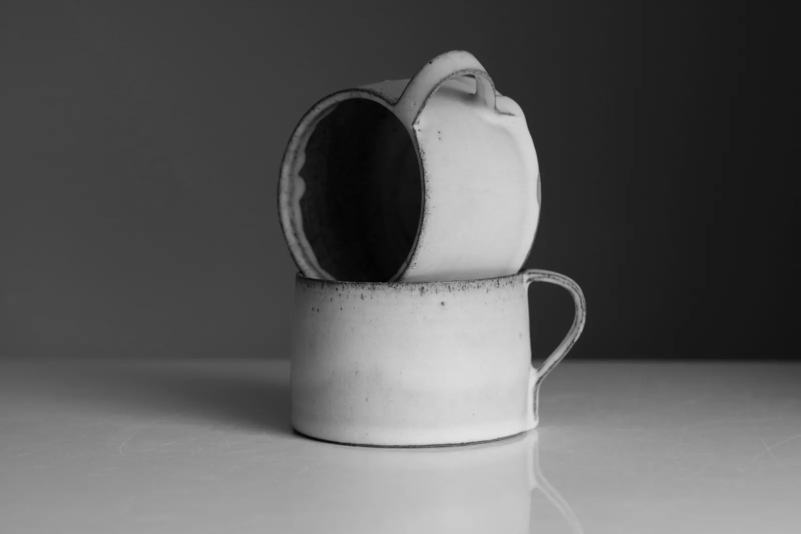 Two speckled mugs stacked on top of each other