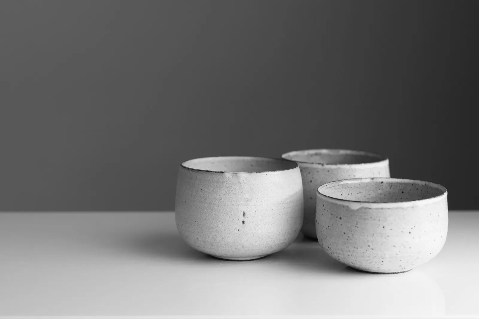 Three speckled stoneware bowls of different sizes