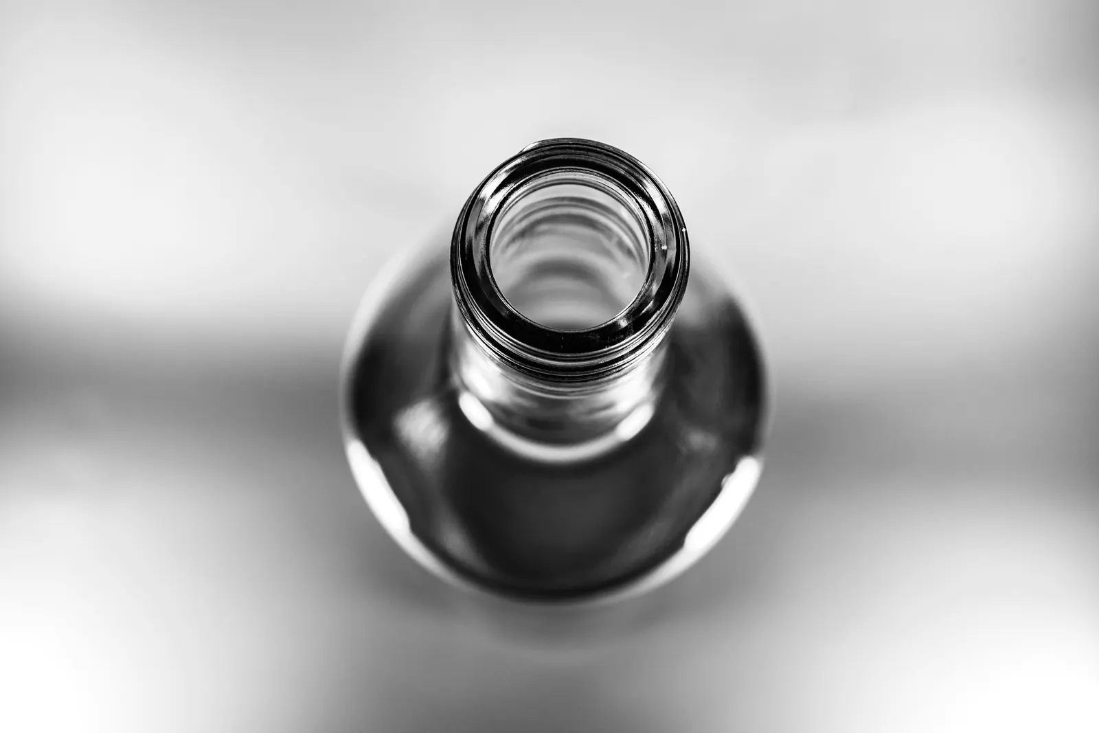 Looking straight down the neck of a clear glass bottle