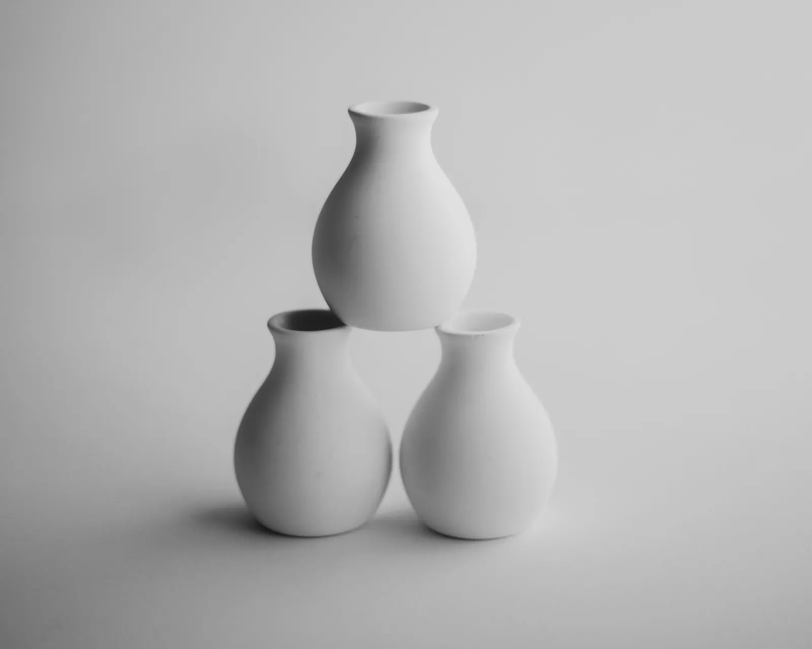 Three white vases stacked in a pyramid
