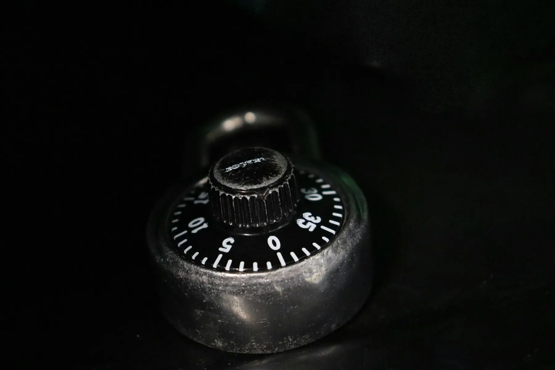 Brass combination dial on a dark safe door