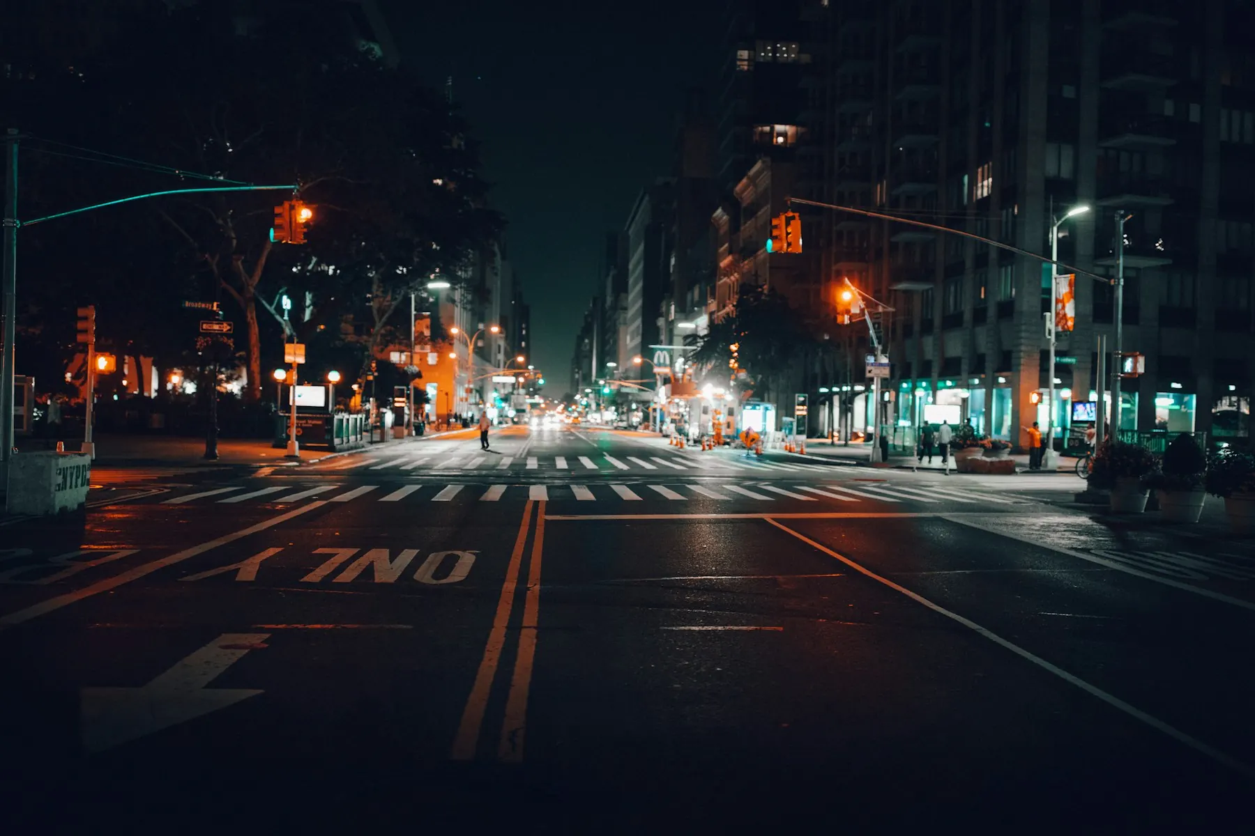 City street at night, wet pavement reflecting office light