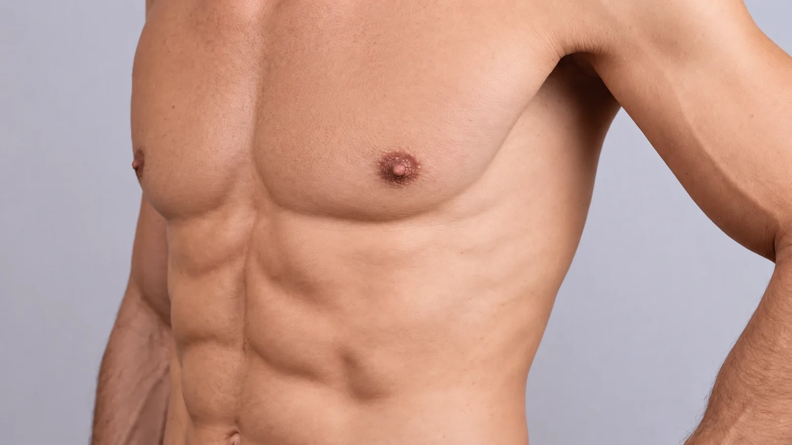 A broad, well-defined male chest and upper abdomen in soft studio light