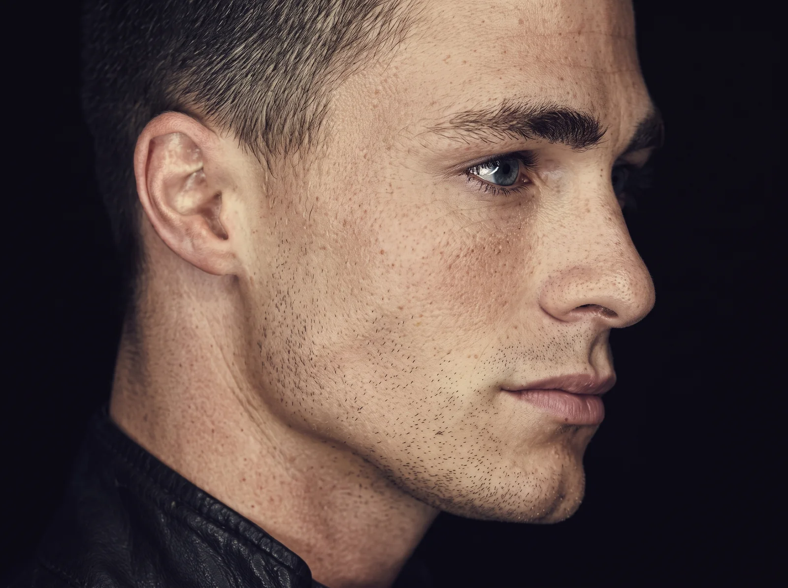 A man in side profile with a strong, sharply defined jawline